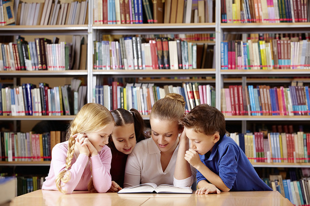 Children gathered around a table at a library.