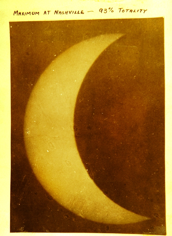 A vintage, sepia-toned photograph of a bright crescent moon against a dark sky. Handwritten text at the top reads "Phases of Eclipse - 1917."