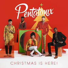 Album cover for the Pentatonix record Christmas is Here! Five musicians stand amongst colorful shapes in front of a red background.