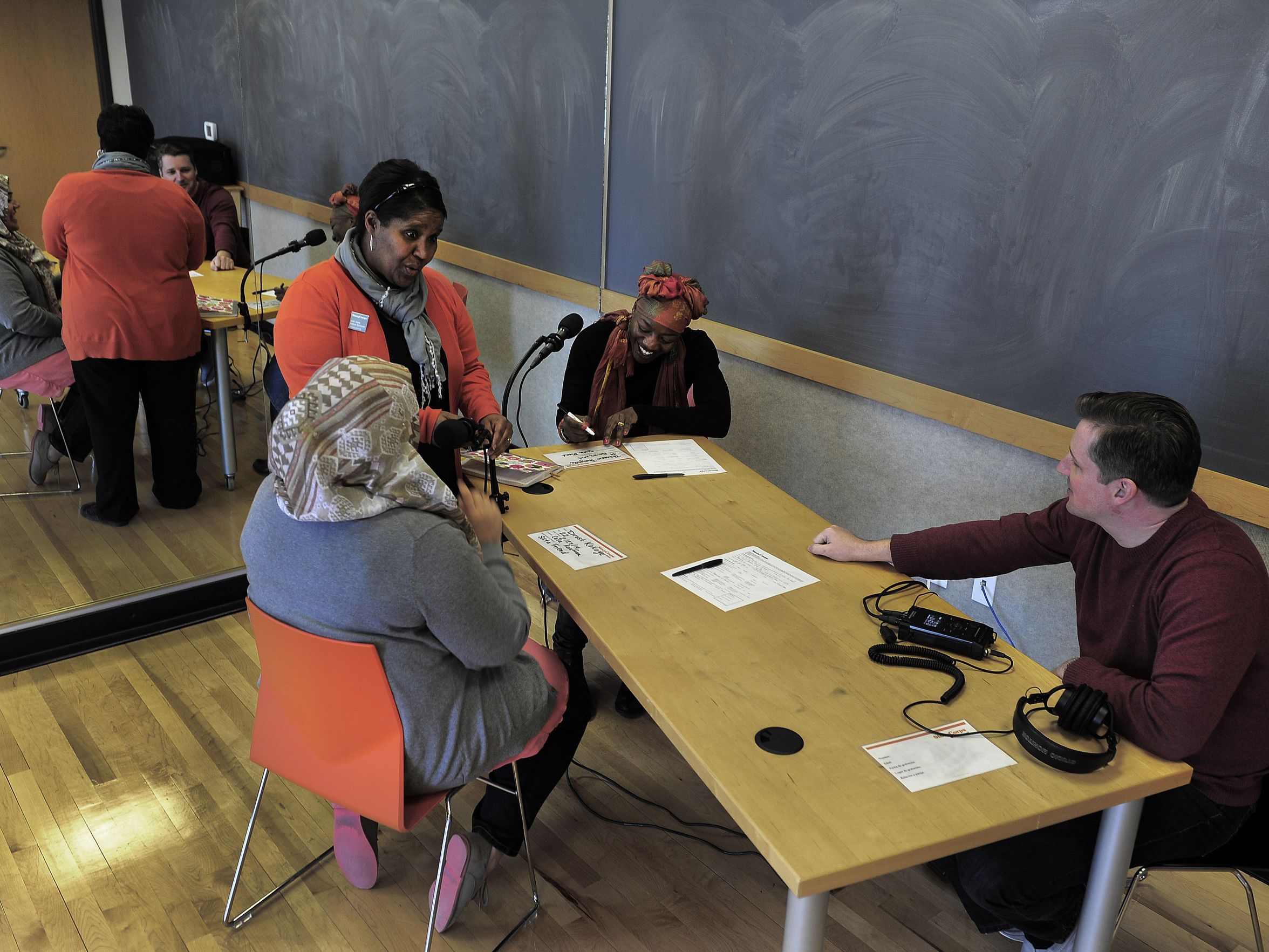 Group of people at a table recording stories.