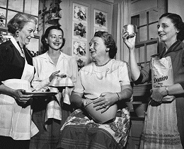 A black and white photo showing four women in the kitchen using Domino sugar.