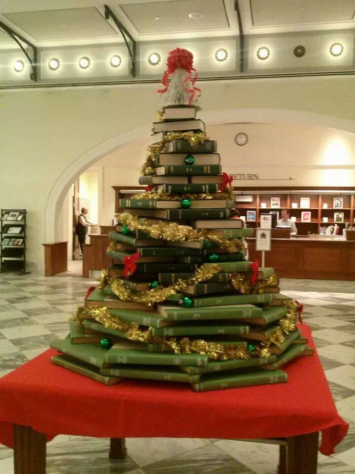 Christmas tree made up of green books sits on a red table in the lobby of the downtown Nashville library.