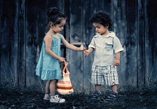two small children helping each other