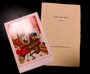 Archival display showing a vintage Christmas card next to a pamphlet that reads Happy New Year.