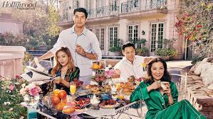 Two men and two women sit in a garden at a table laid out for breakfast.