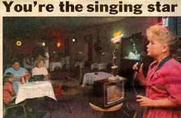 A woman in a pink dress speaks into a microphone at an event, with blurred guests sitting at tables in the background. The text "You're the singing star" is at the top of the image.