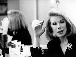 Joan rivers, a woman with long blonde hair wearing a dark suit.