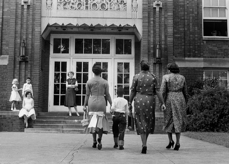 First day of desegregation on September 9, 1957, shows a mother walking a little boy to school.