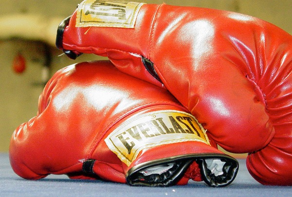 Two red boxing gloves sit on the floor.