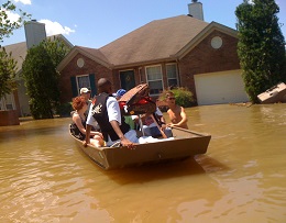 A boat filled with people floats down a neighborhood street during the 2010 flood.