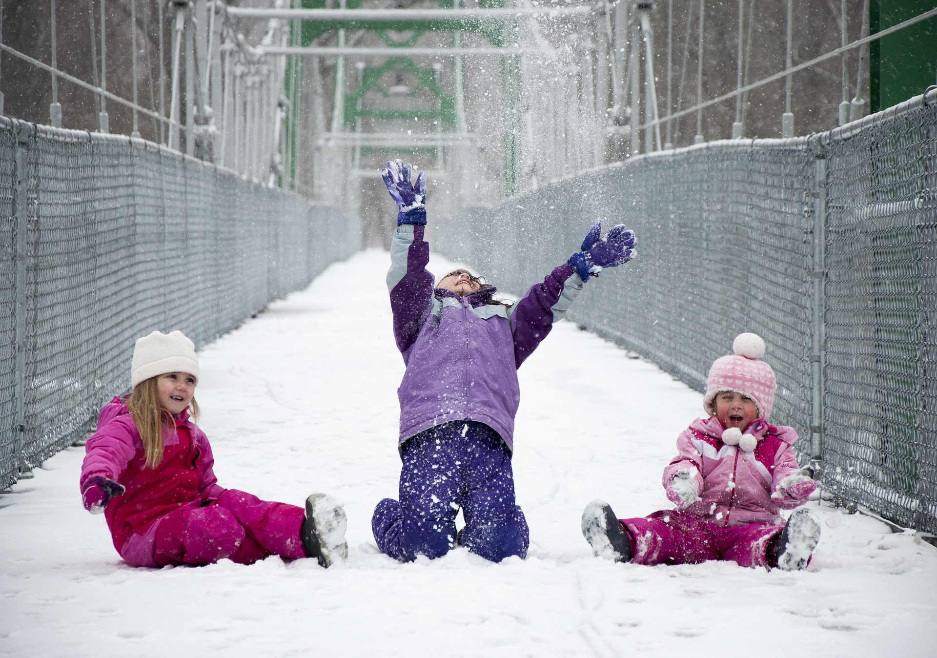Three girls playing in the snow.