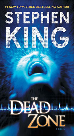 The book cover for Stephen King's "The Dead Zone," featuring a glowing blue face and an EKG line on a dark background.