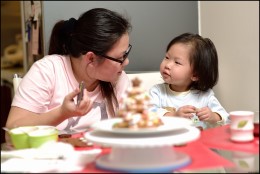 woman is visiting with child at a kitchen table set with tea.