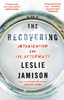 Book cover for "The Recovering: Intoxication and its Aftermath" by Leslie Jamison, viewed through the bottom of a glass.