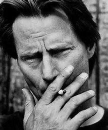 Closeup of Sam Shepard smoking.