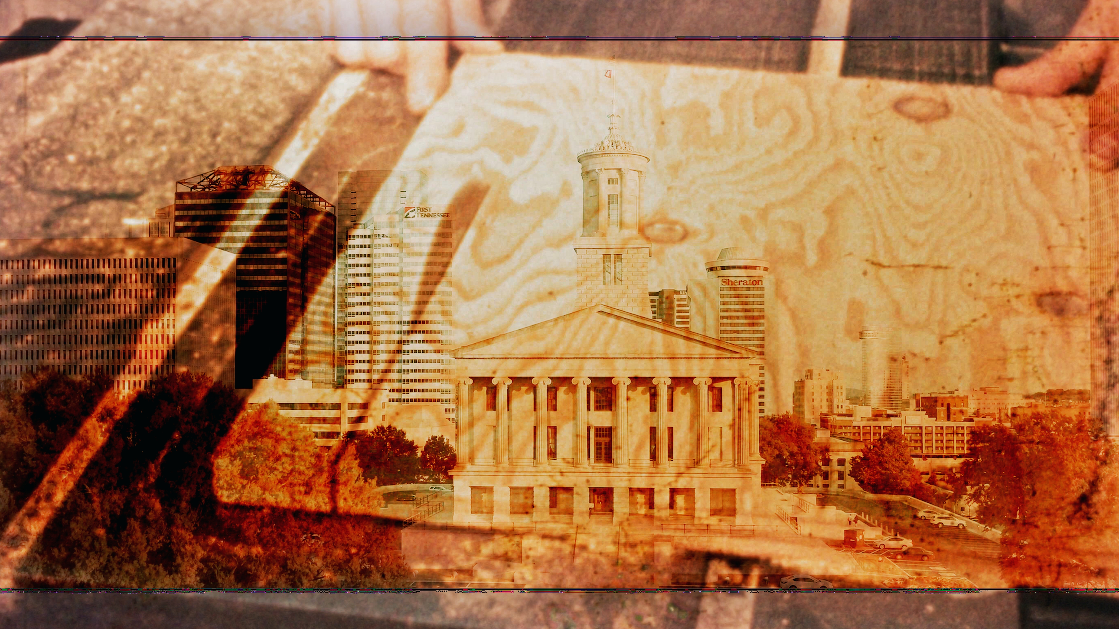 Old sepia photo showing buildings in a downtown city.