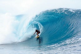 Person surfing through the tube of a big wave.