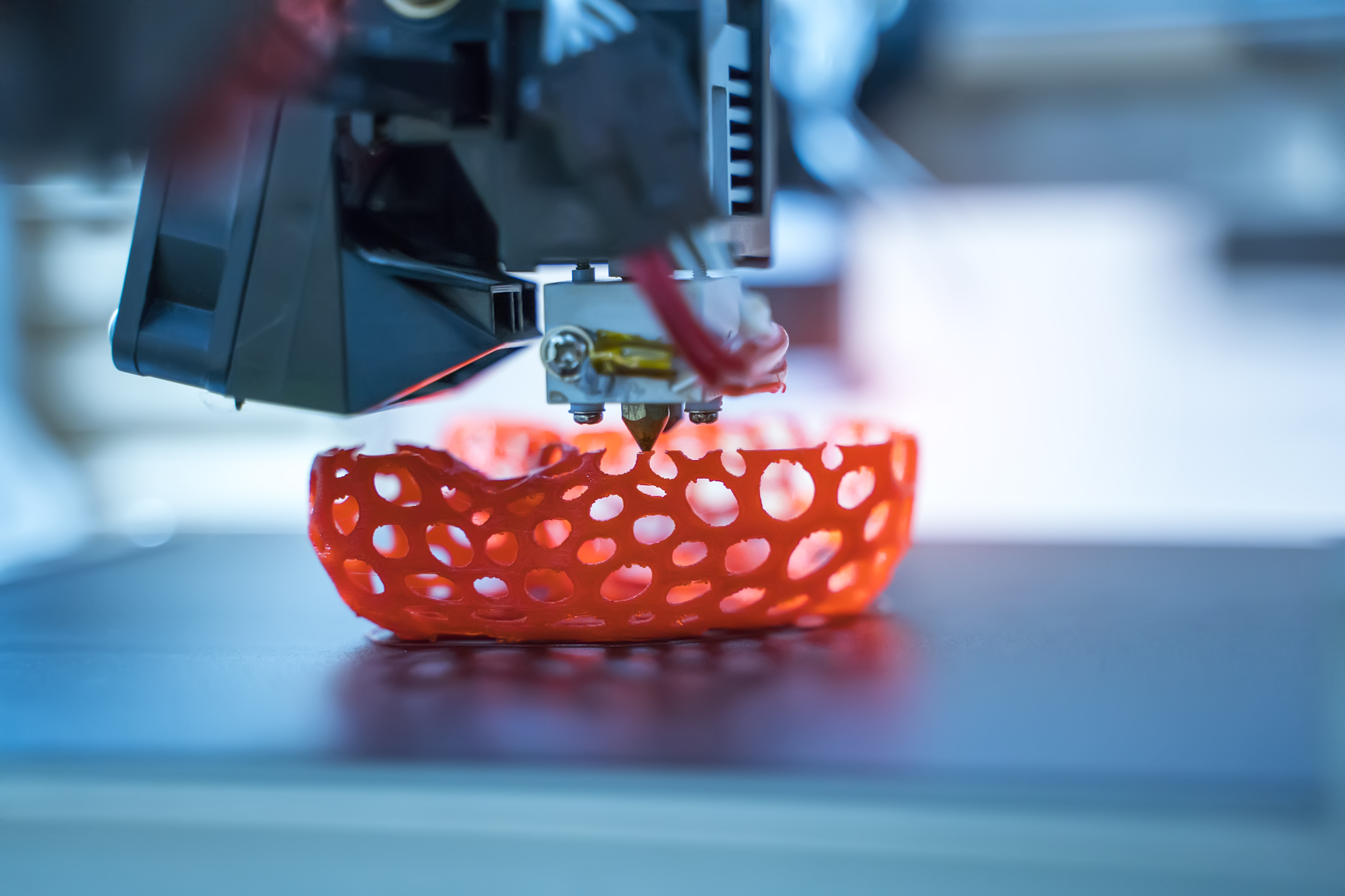 A 3D printer printing something orange.