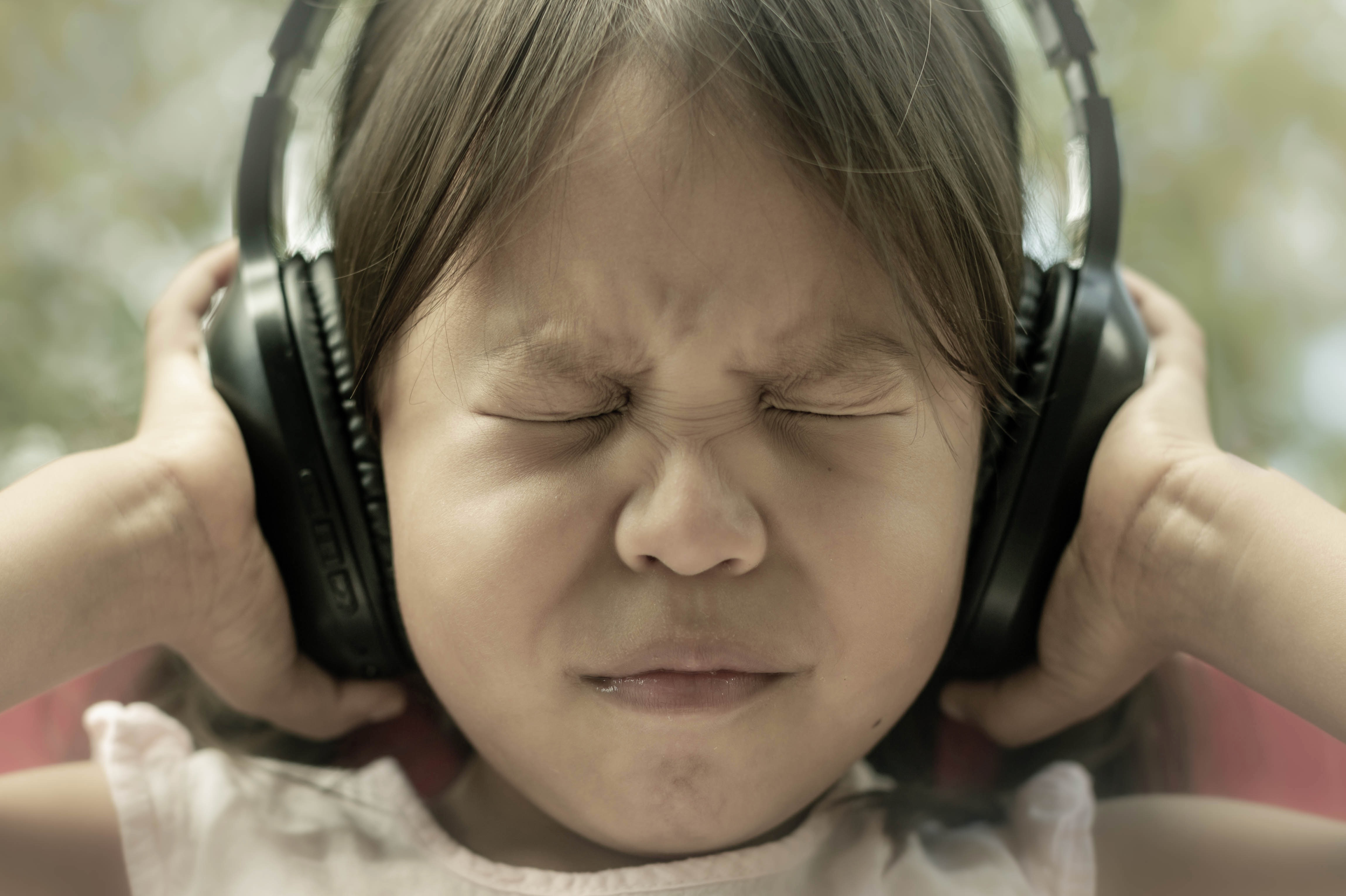 Child with hands over ears to block noise.