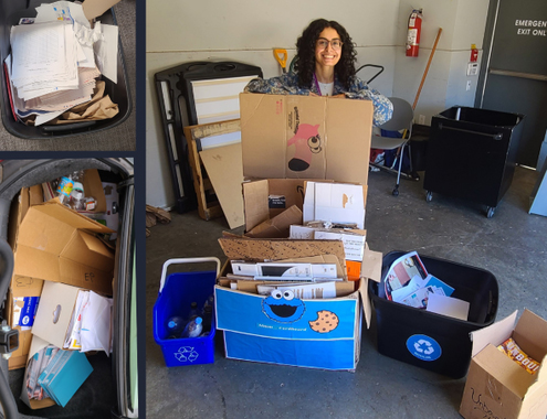 A woman peers over a tall stack of cardboard boxes and plastic bins filled with various household items in a garage or storage area.