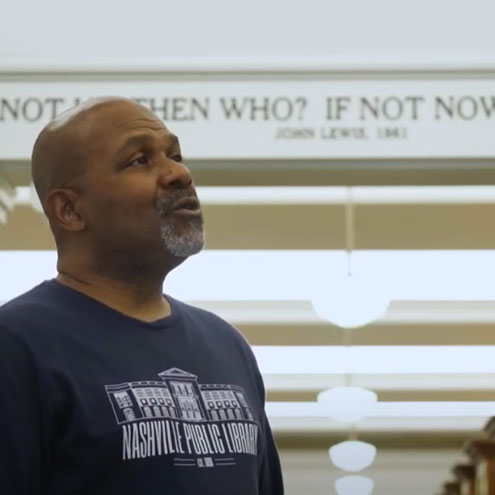 Man stands in Civil Rights Room singing