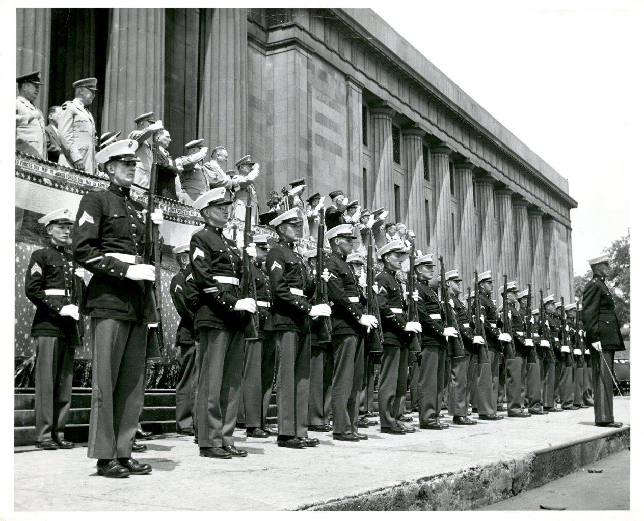 Photograph. Marine Corps in uniform, lined up in front of War Memorial Building.
