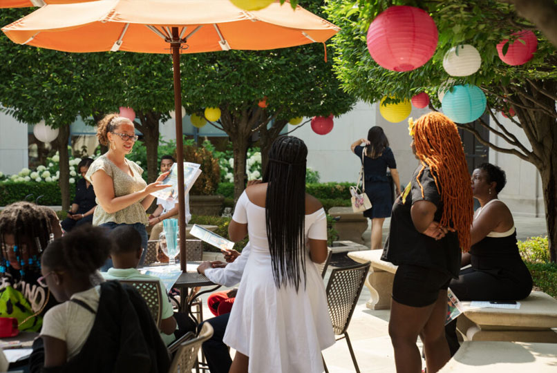 A group of teenagers in the main library courtyard, which is decorated with paper lanterns. 