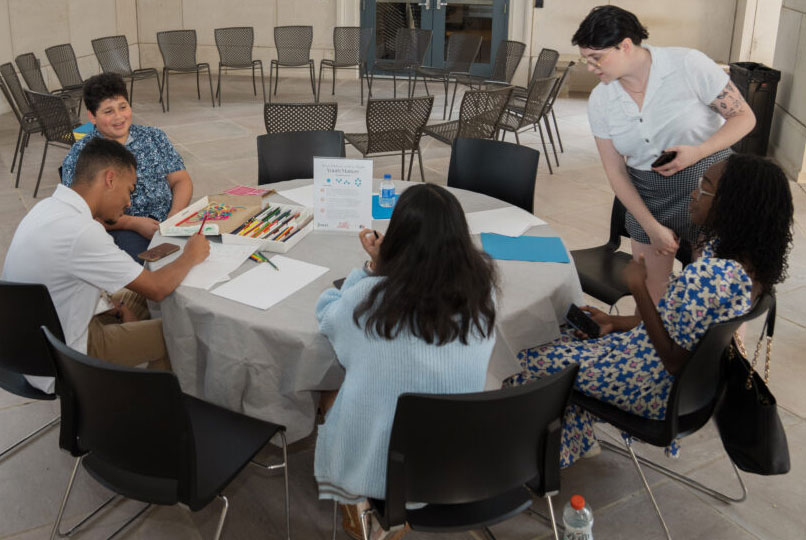 Group of teenagers at a NAZA group drawing on paper.