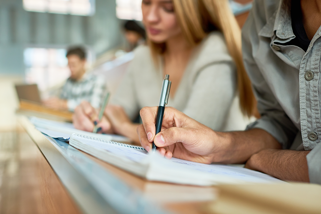 Adults writing on paper.