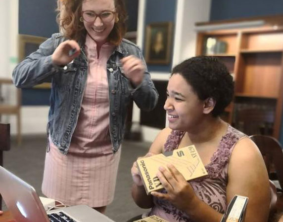 Two women digitizing VHS tapes.