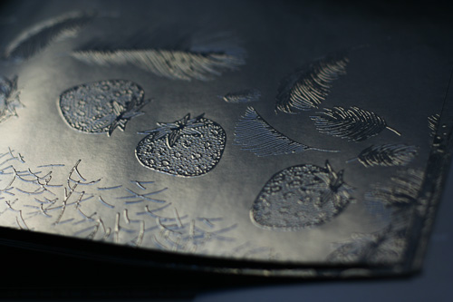 Close up image of embossed piece of silver cloth.