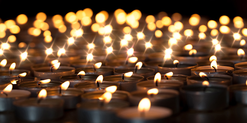 Grouping of tea lights on a black background.