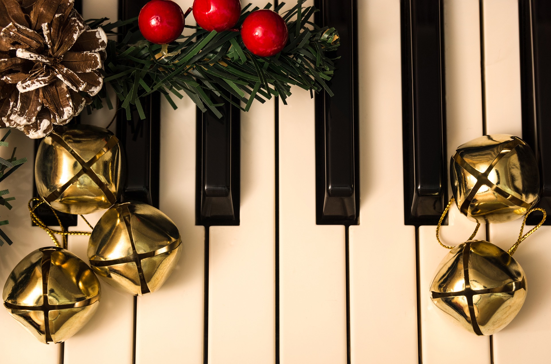 Jingle bells resting on a piano keyboard.