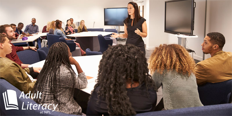 Female teacher speaking to adult students.