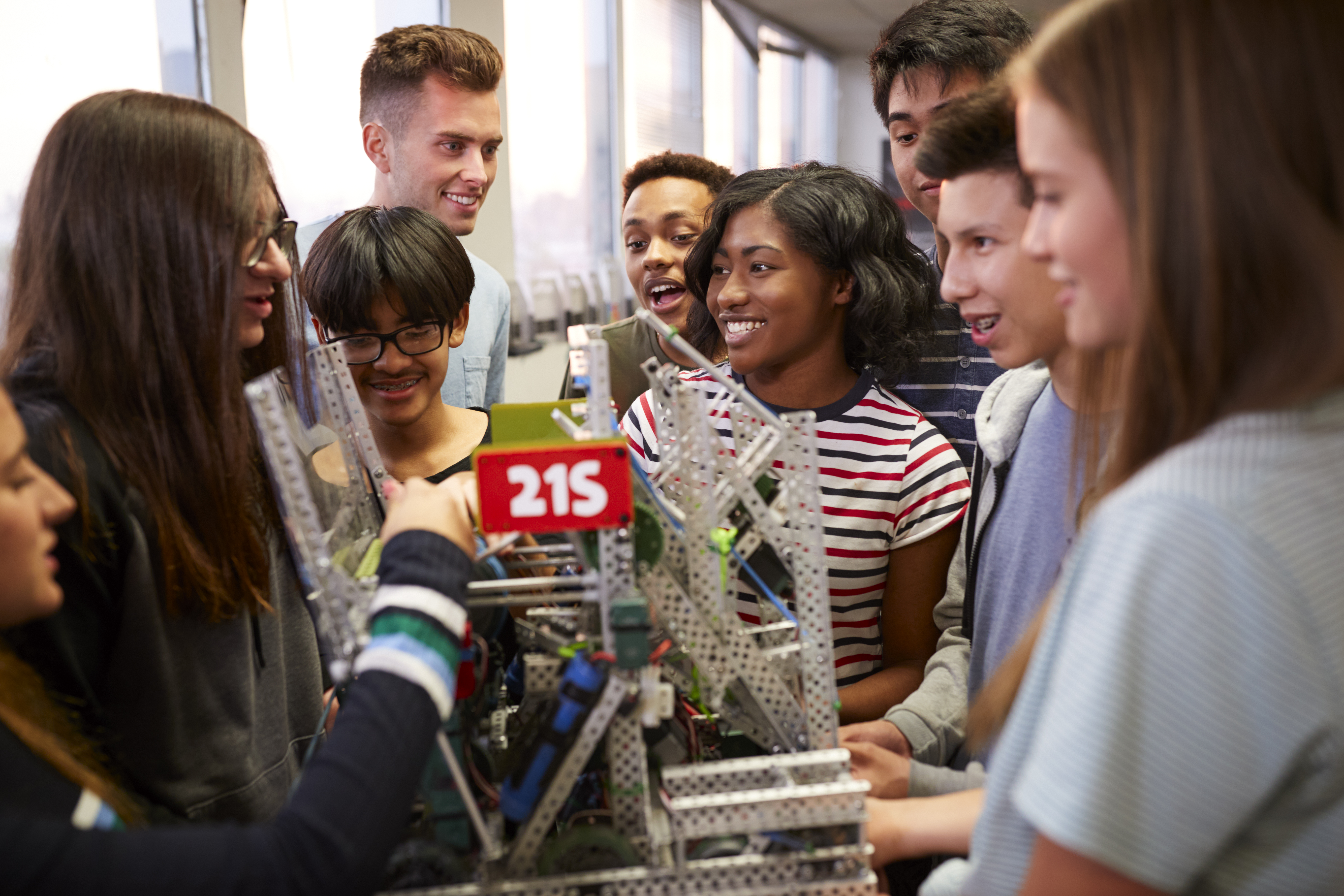 Group of teens building a robot. 