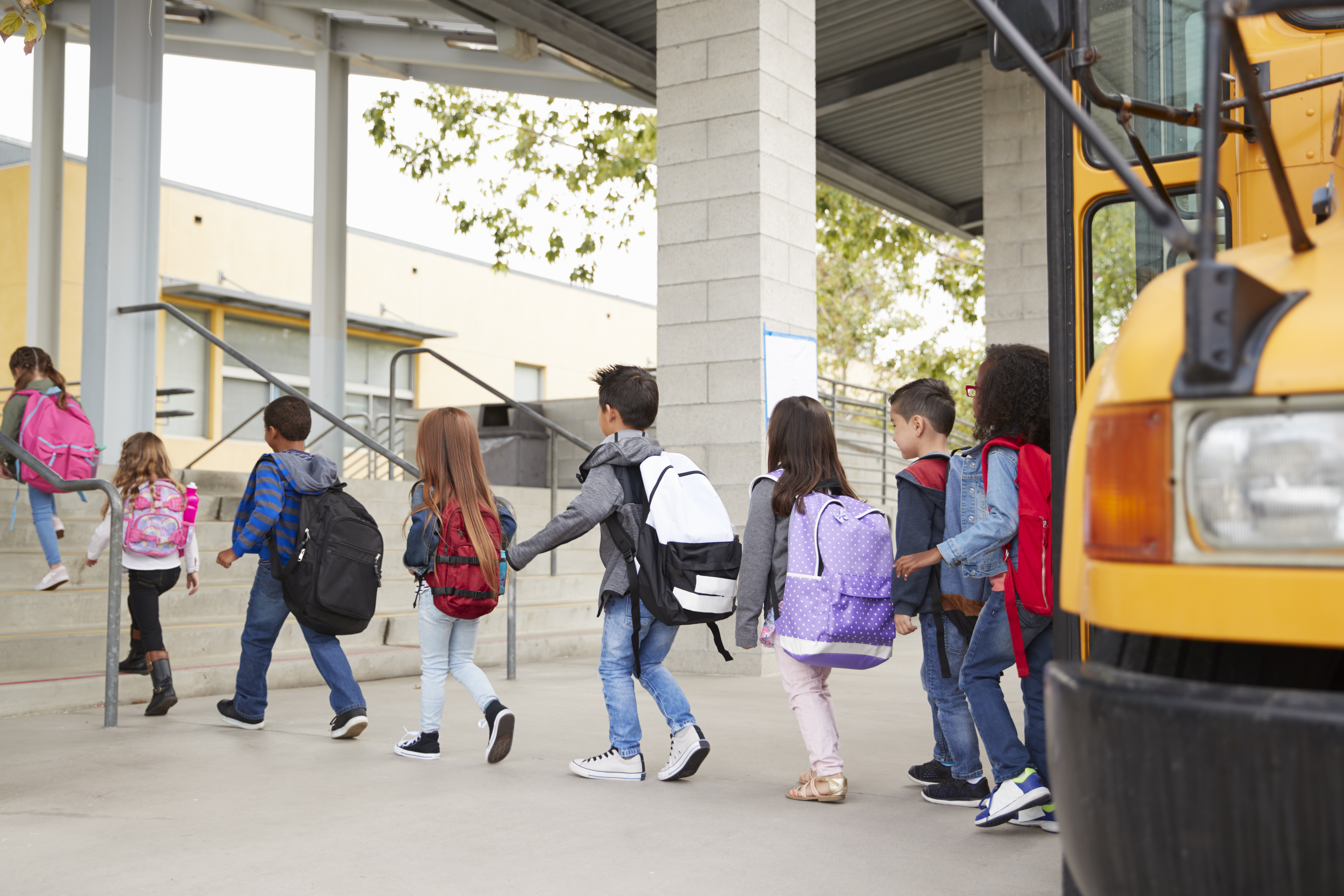 Photograph. Children disembarking from school bus.