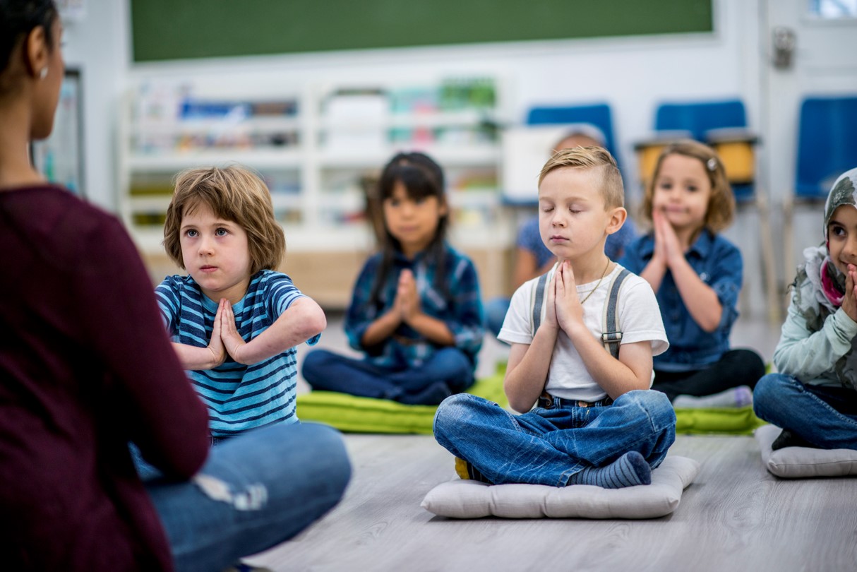 Photograph. Children practice yoga.