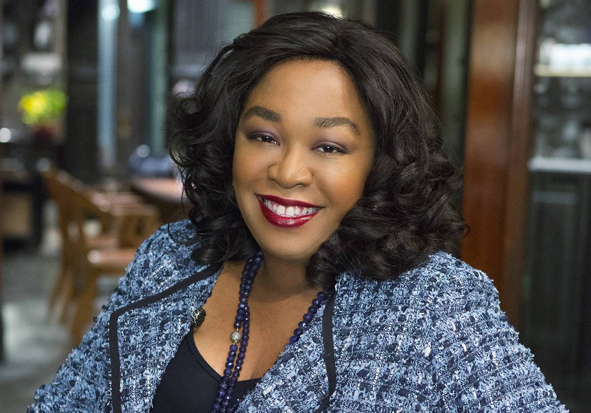 Headshot of Shonda Rhimes, a black woman with long dark hair and a blue tweed jacket