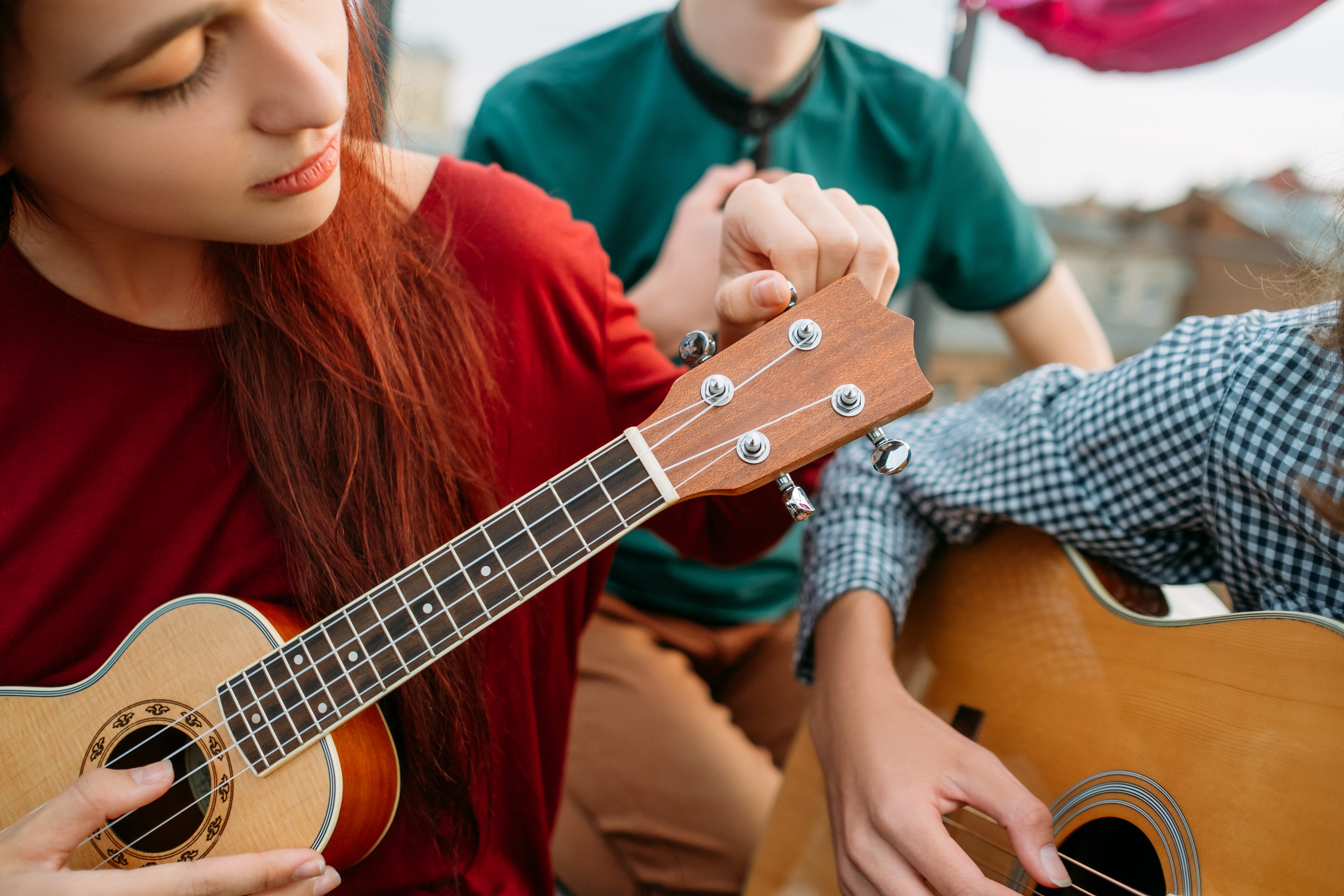 Young child tuning a ukulele