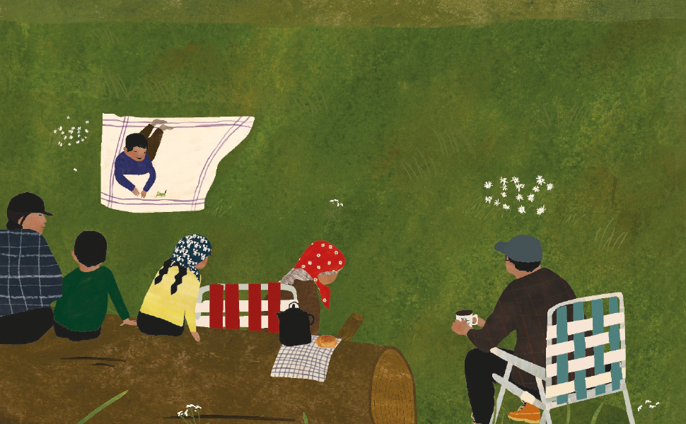 Boy laying on a white blanket on a green lawn with family members nearby