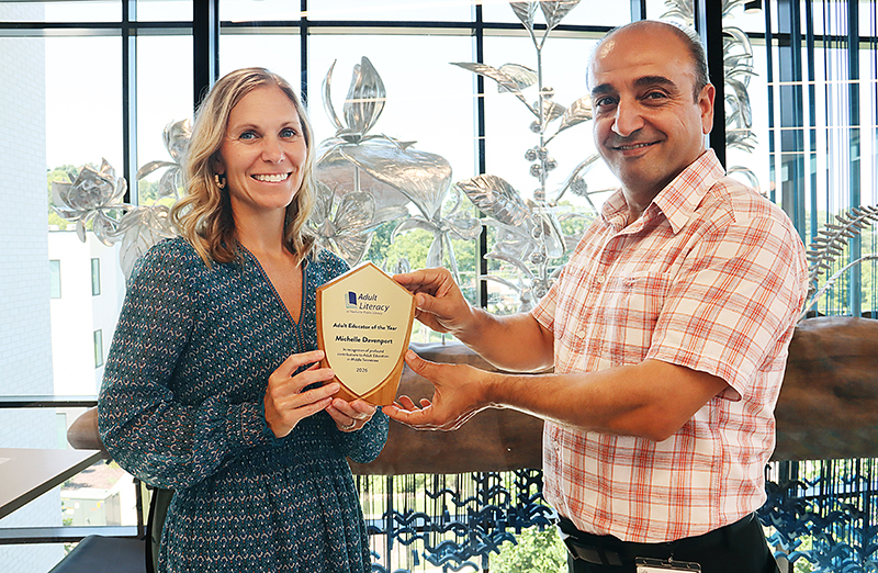 Michelle Davenport receiving her Educator of the Year award from NPL's Jamil Sameen