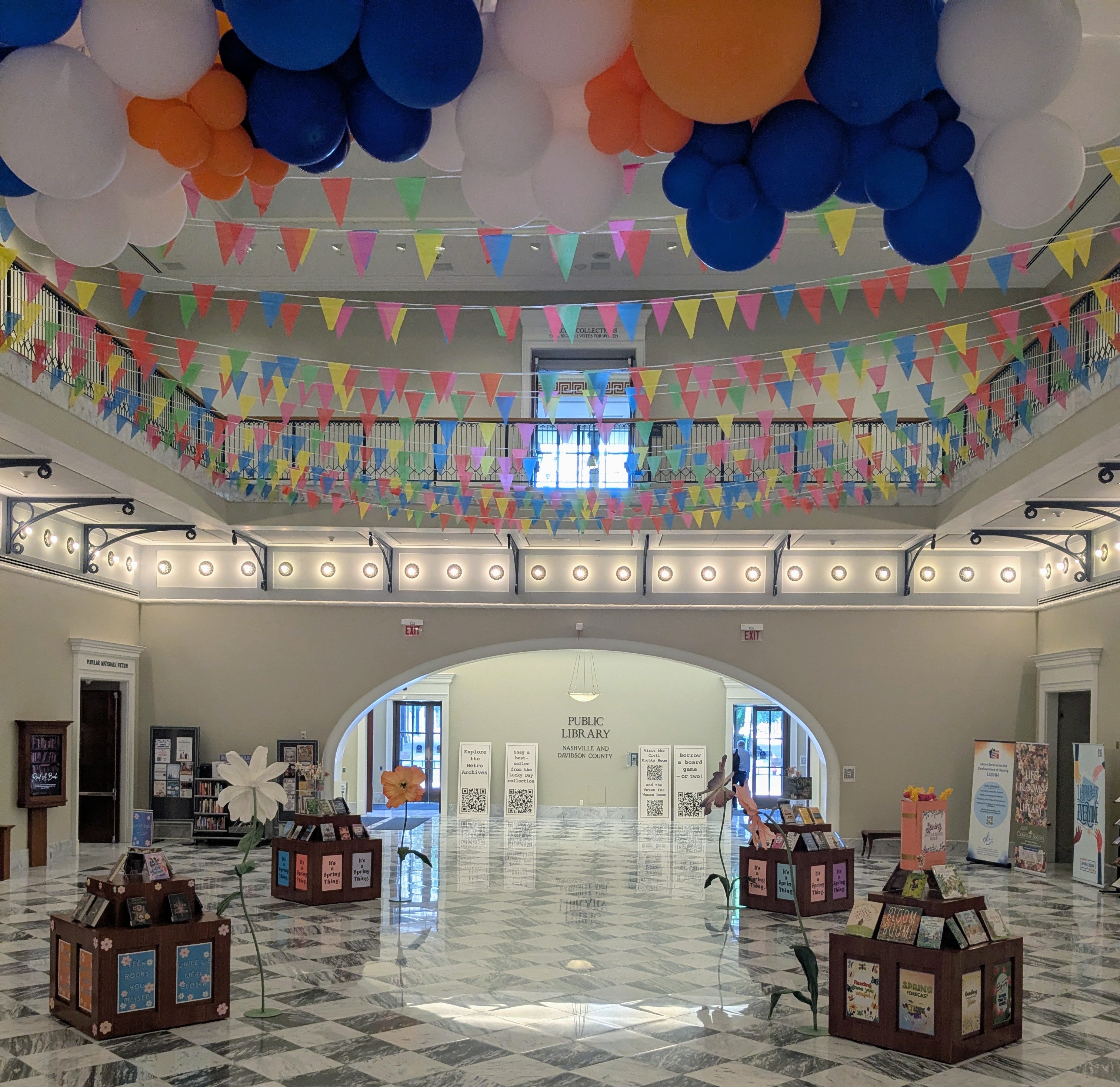 Photo of the Main Library lobby decorated with balloons and multicolor banners.