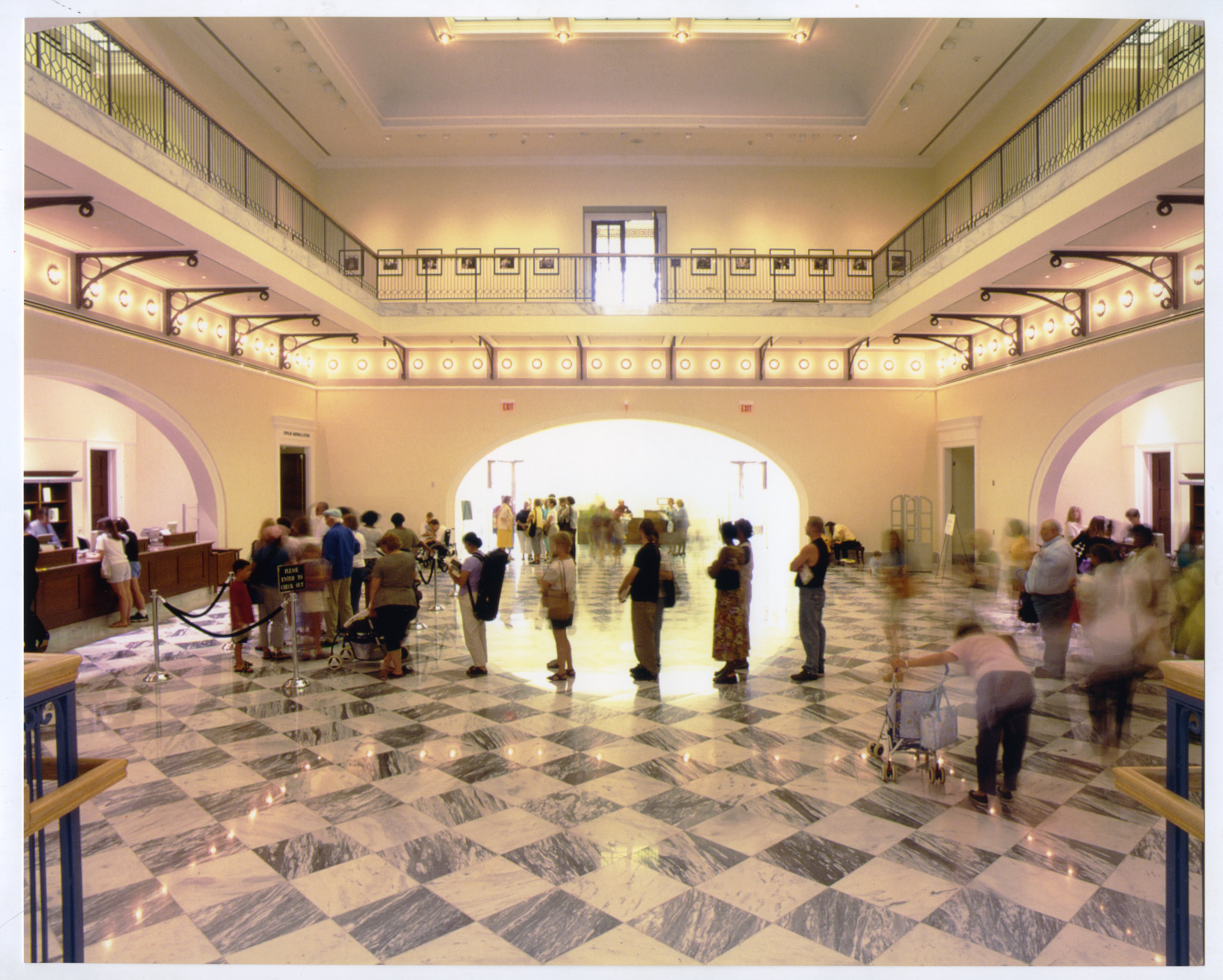People standing in line at the circulation desk in the lobby of the Main Library