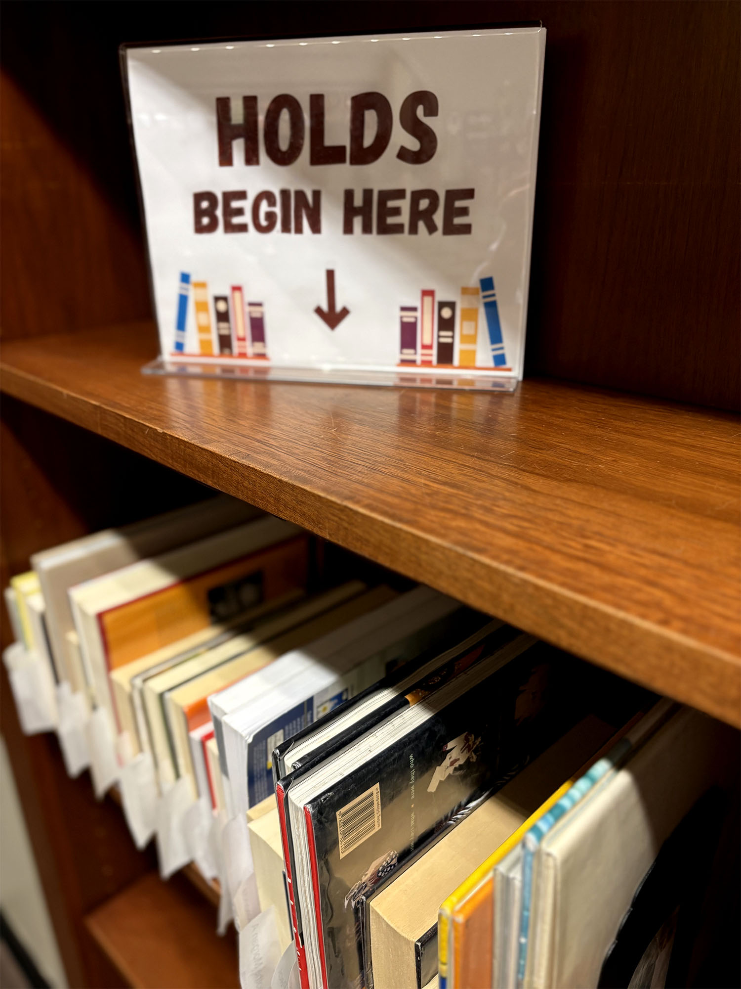 Holds shelf with books waiting to be picked up.