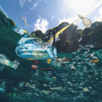 Plastic garbage floating on water as seen from under the water.