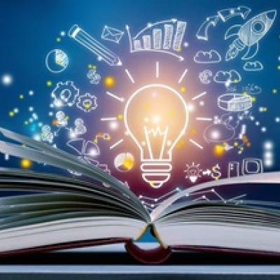 Lightbulb drawing floating over an open book.