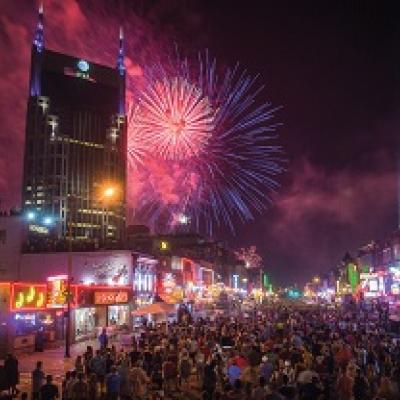 View of fireworks in downtown Nashville from crowded Broadway.