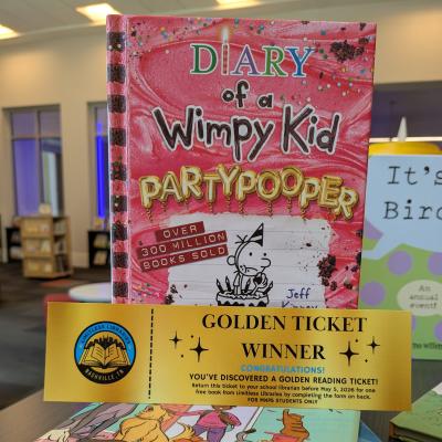Diary of a Wimpy Kid book with Golden Ticket award in front.