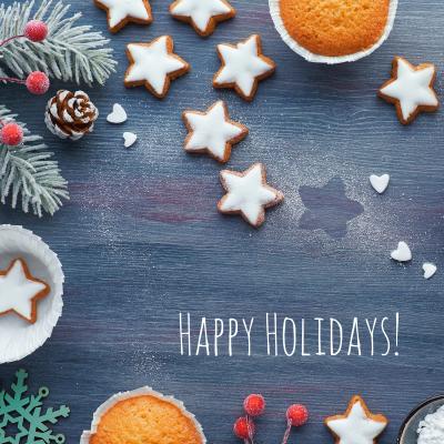 Happy Holidays against a blue background showing star shaped cookies and hot cocoa.