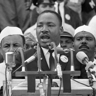 Dr. Martin Luther King Jr. at a podium giving a speech.
